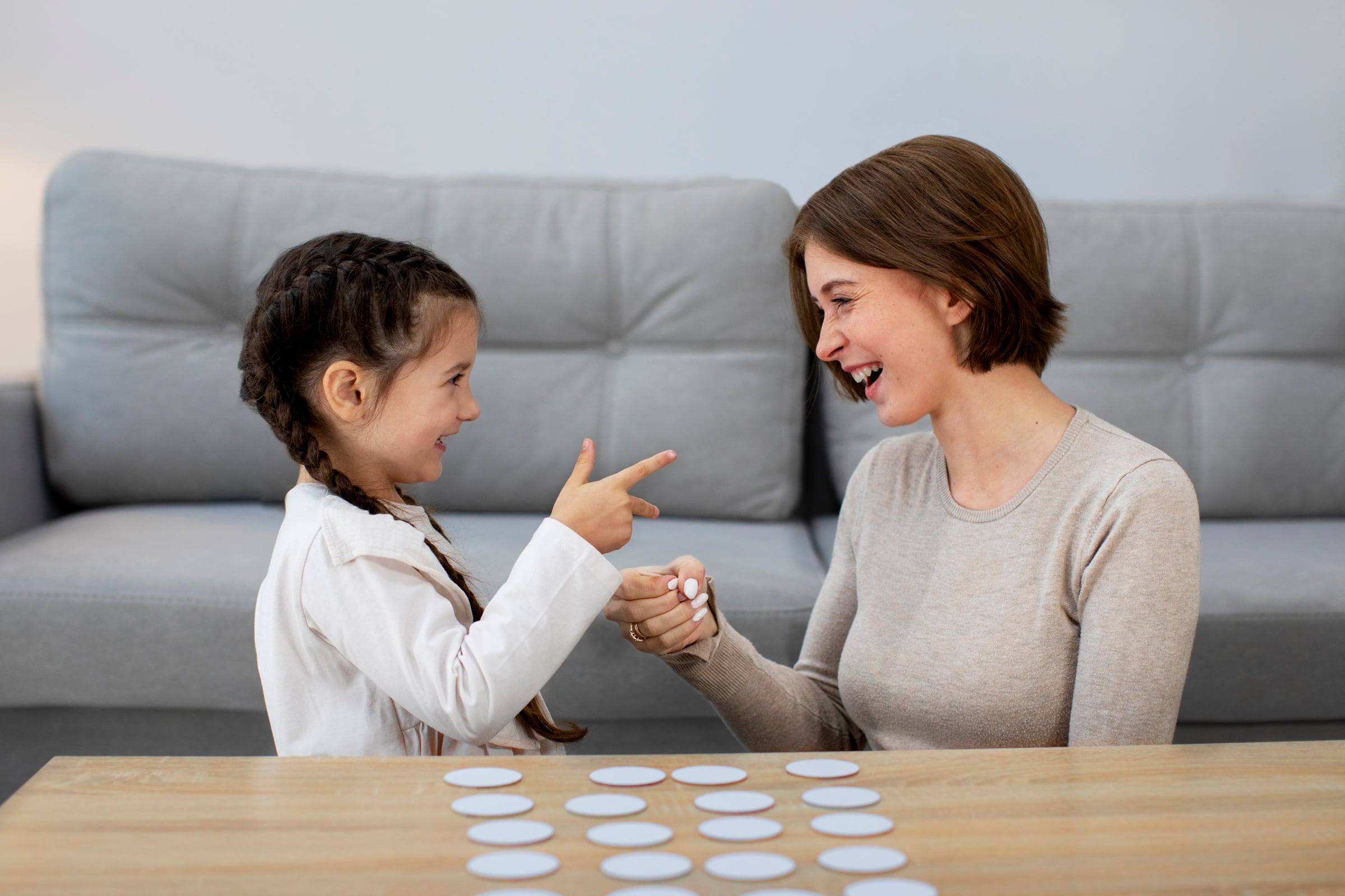 Niña y especialista jugando un juego de memoria