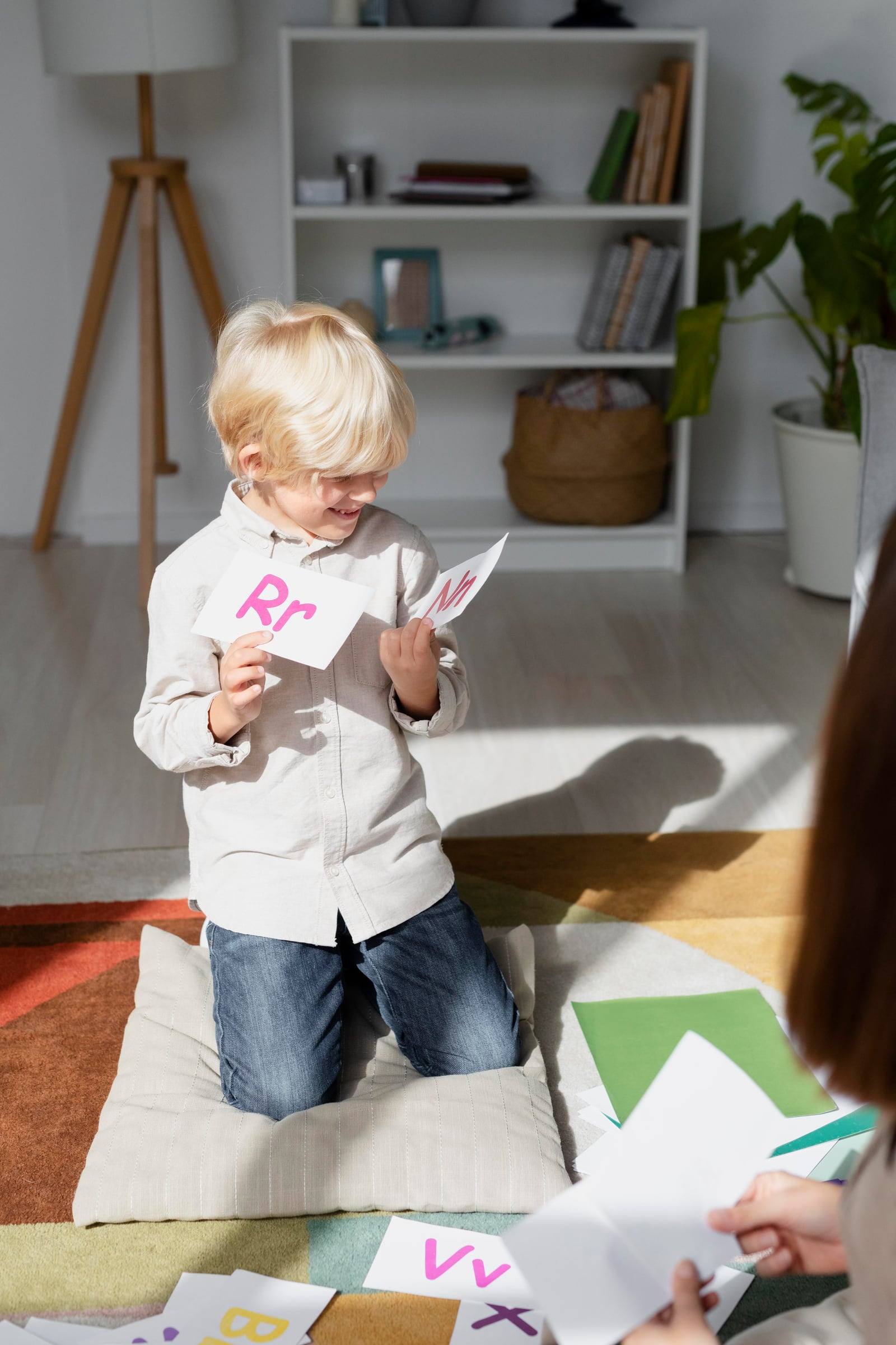 Niño sonriendo con tarjetas de letras