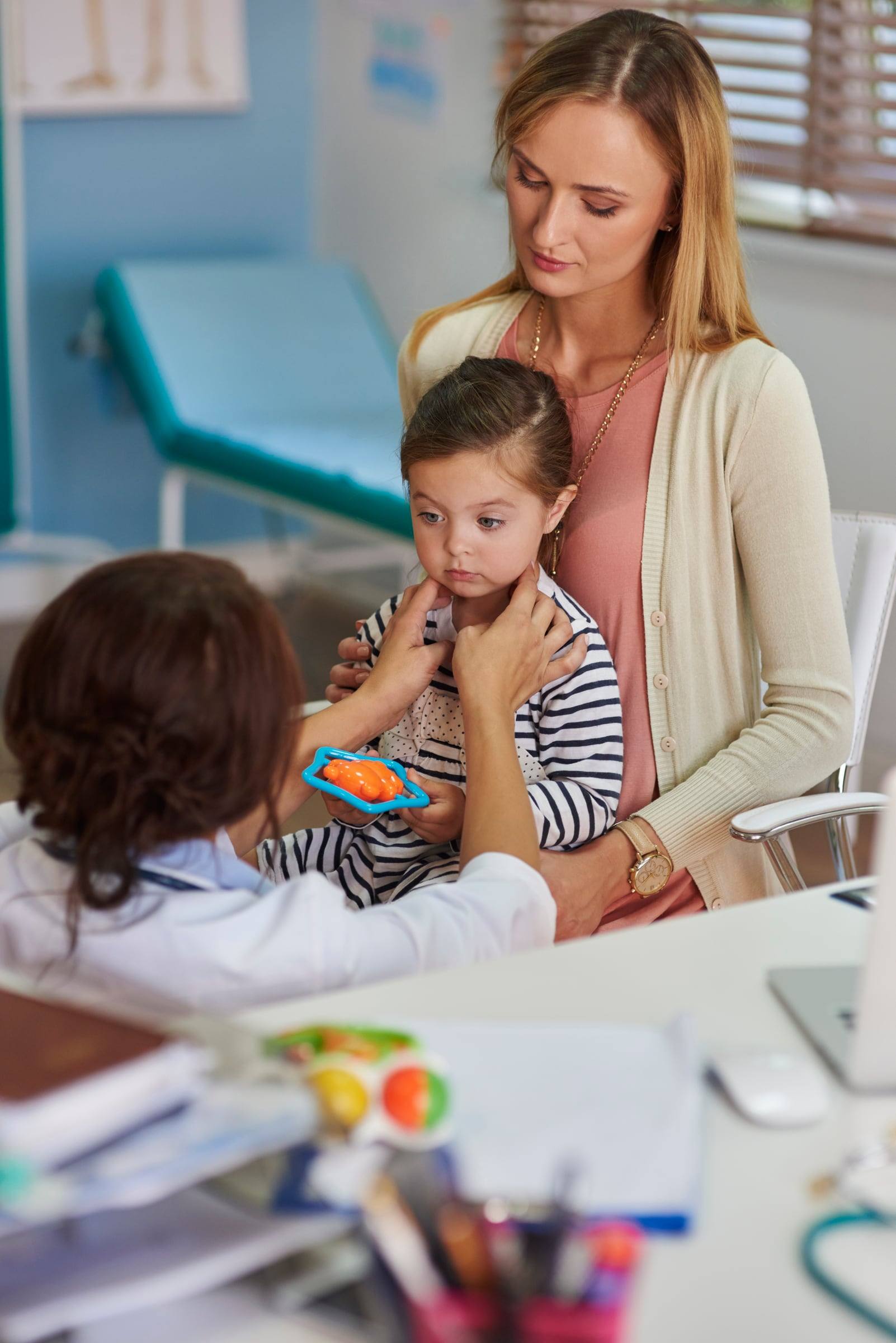 Especialista acompañando a una niña pequeña y a su mamá